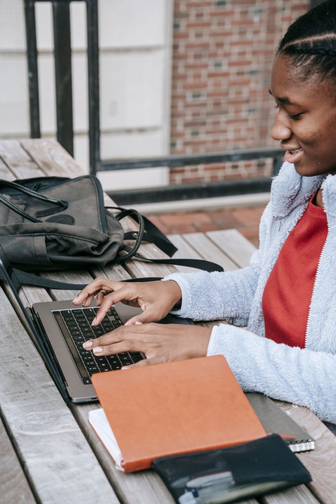 Student checking CMIS on her laptop on campus
